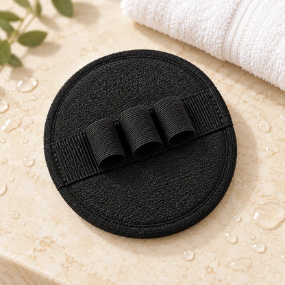 Tressfold round exfoliating bath glove on a warm ivory surface